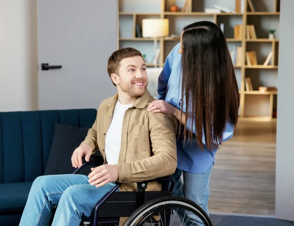 man on wheel chair looking at carer nurse