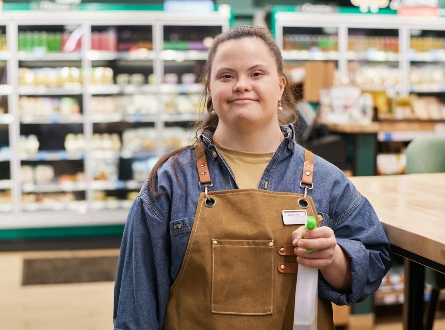 Girl with down syndrome disability working and cleaning a super store