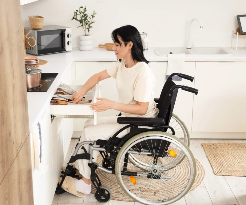 woman on wheelchair cooking